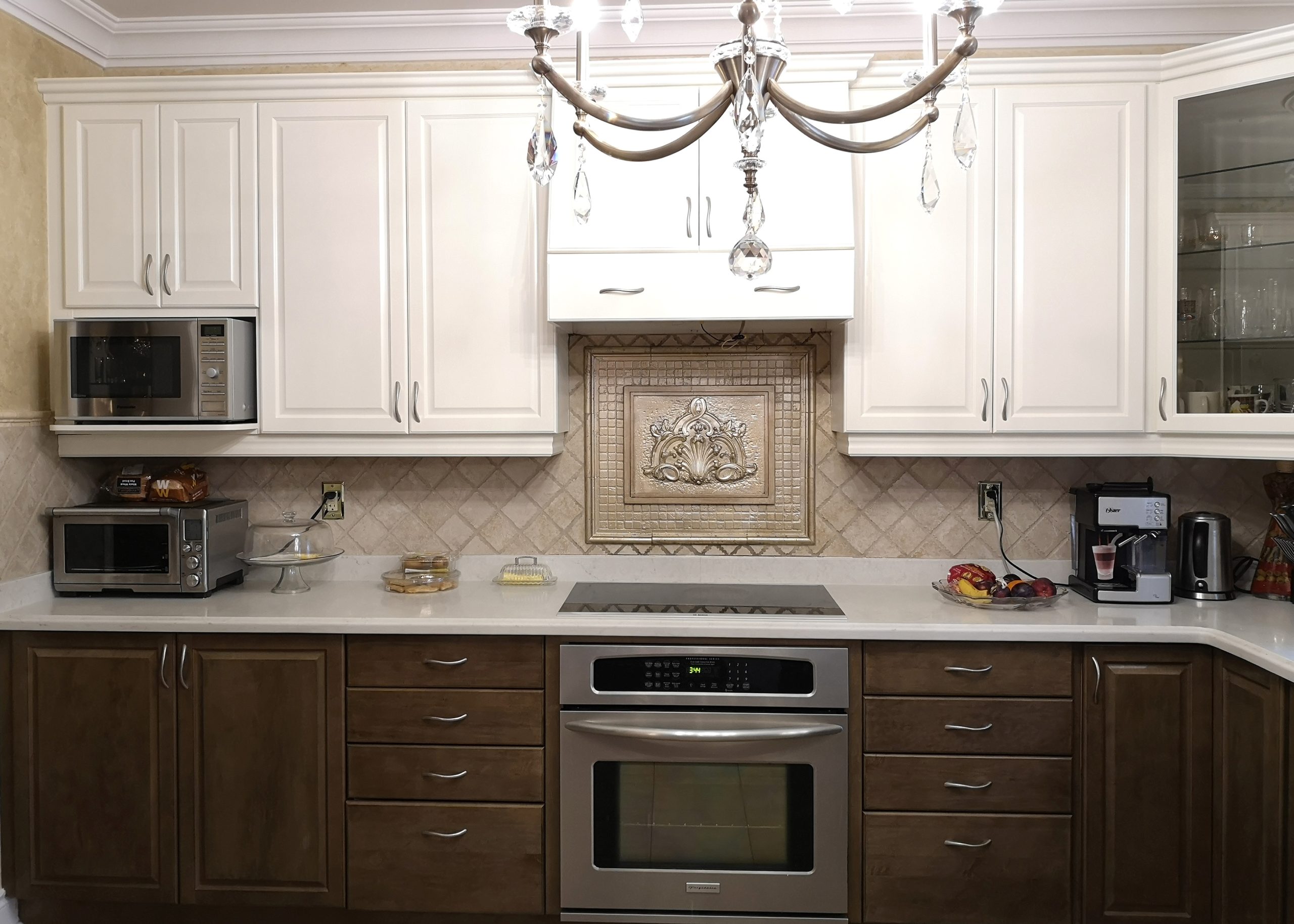 Transformed kitchen cabinets showcasing a two-toned elegance, painted in Benjamin Moore's Linen White OC 146 semi-gloss and sealed with a satin-finish water-based varnish.