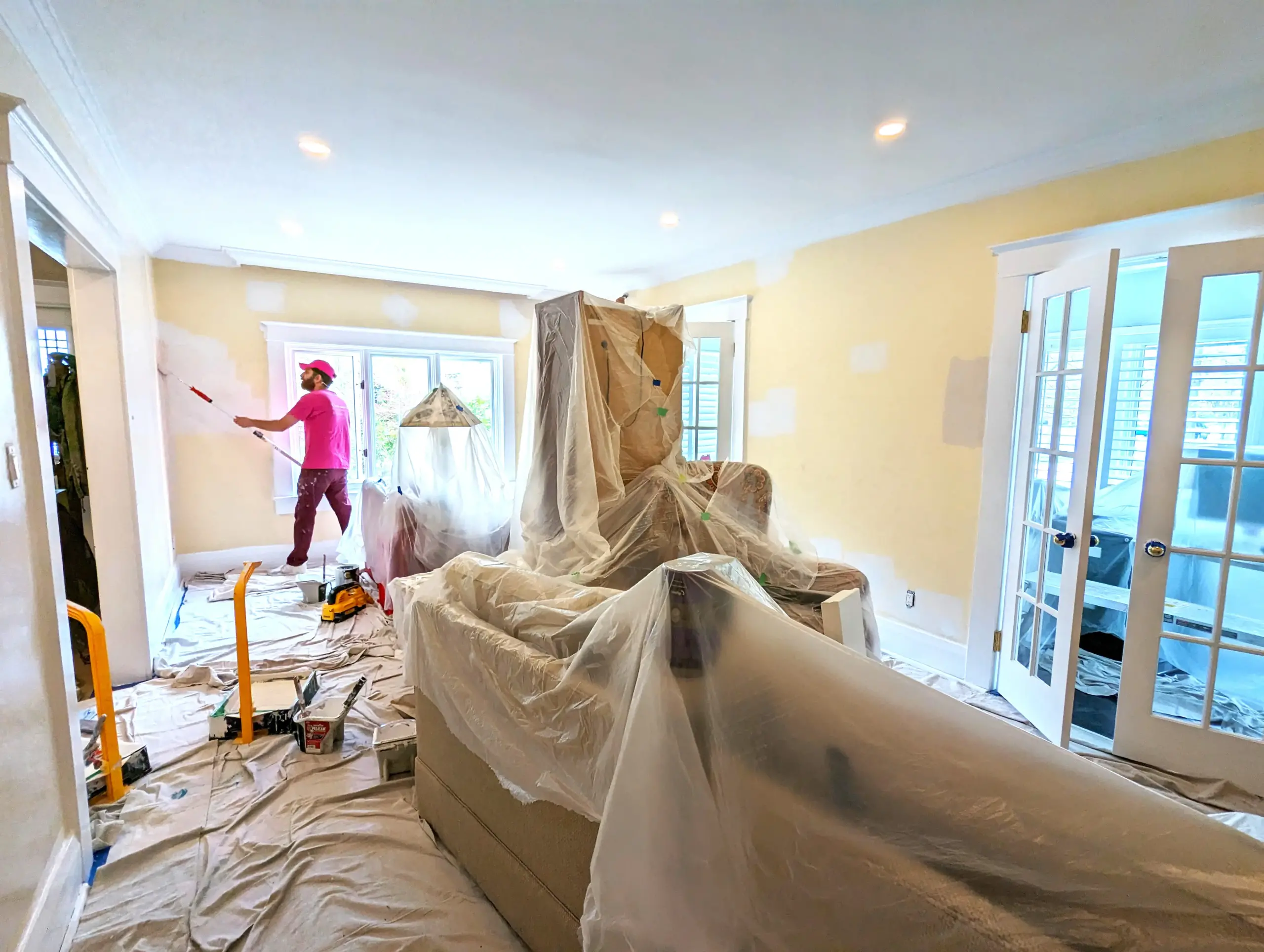 Interior painting contractor working on a full house painting project in Leaside with full furniture