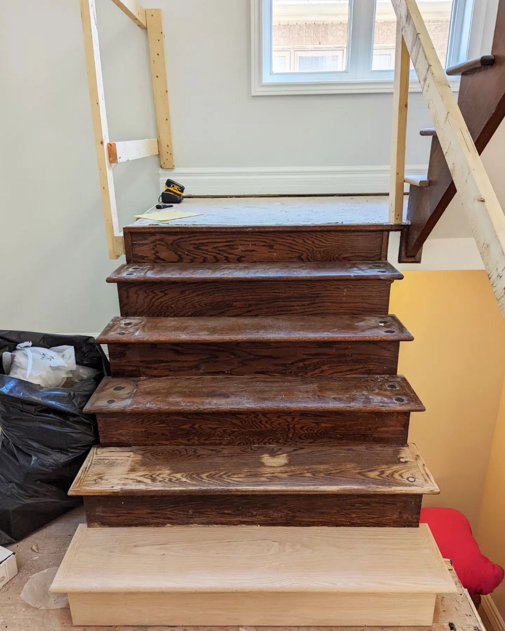 Stairs refinishing project in Oakville during a full renovation of a house. Threads and handrails are stained and varnished masterfully. The wall stringers and risers are painted in pure white by Sherwin Williams.