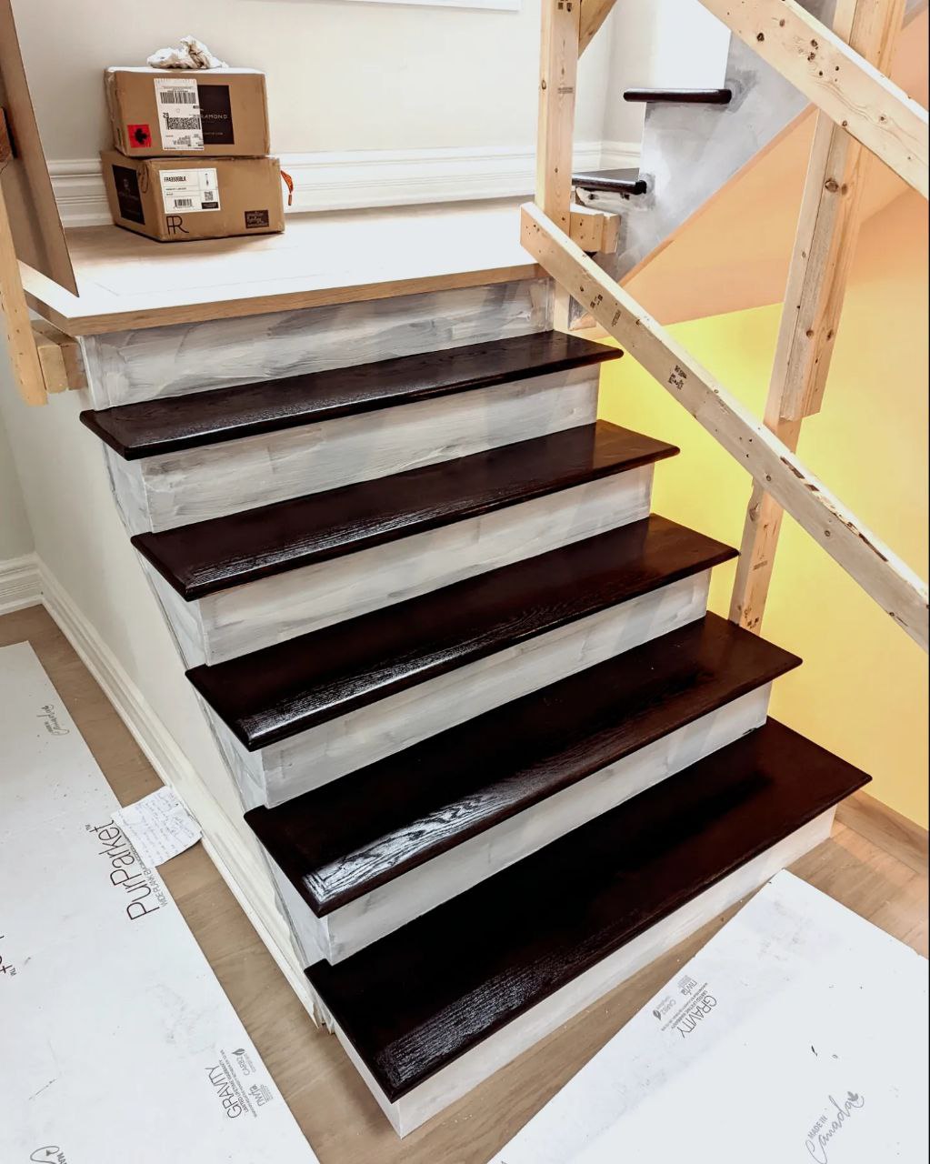 Stairs refinishing project in Oakville during a full renovation of a house. Dark Espresso stain application on treads, primed risers.