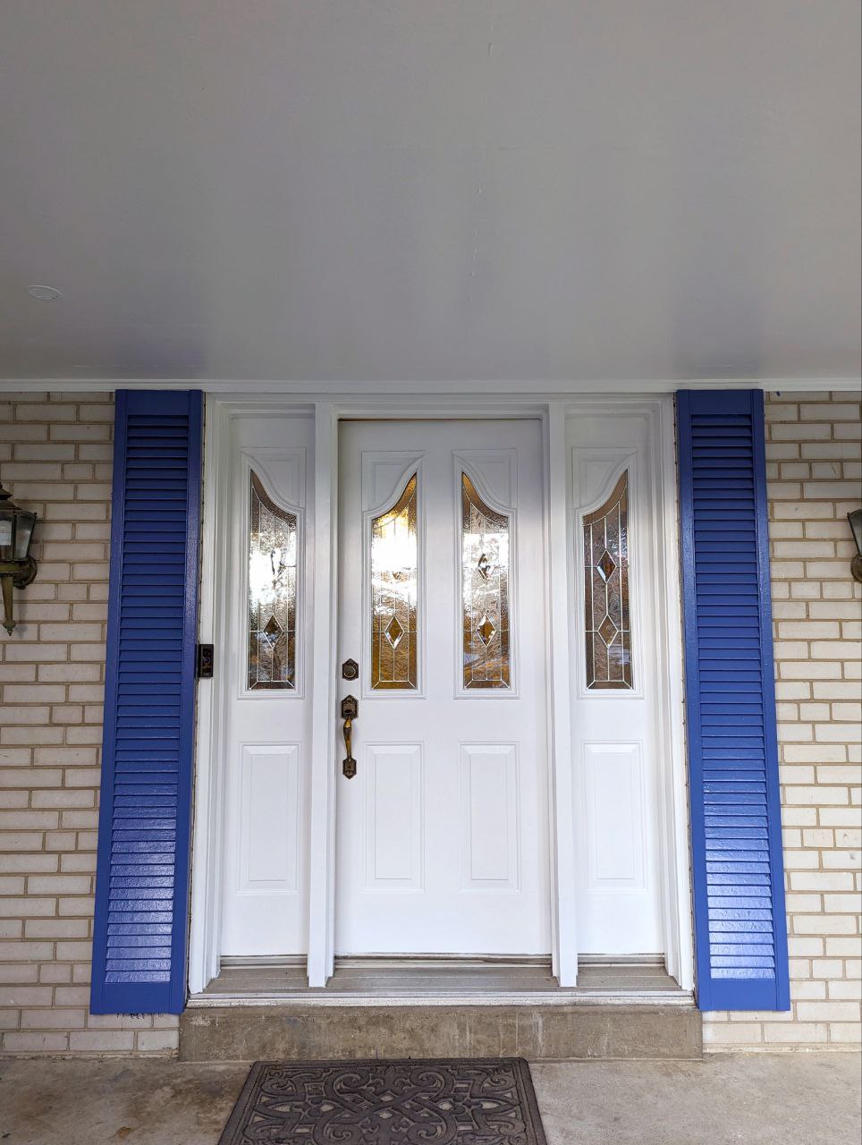 Exterior painting project in North York, Toronto: shutters painted in a nice rich blue by BenjaminMoore and the entrance door freshened up in the existing white colour.