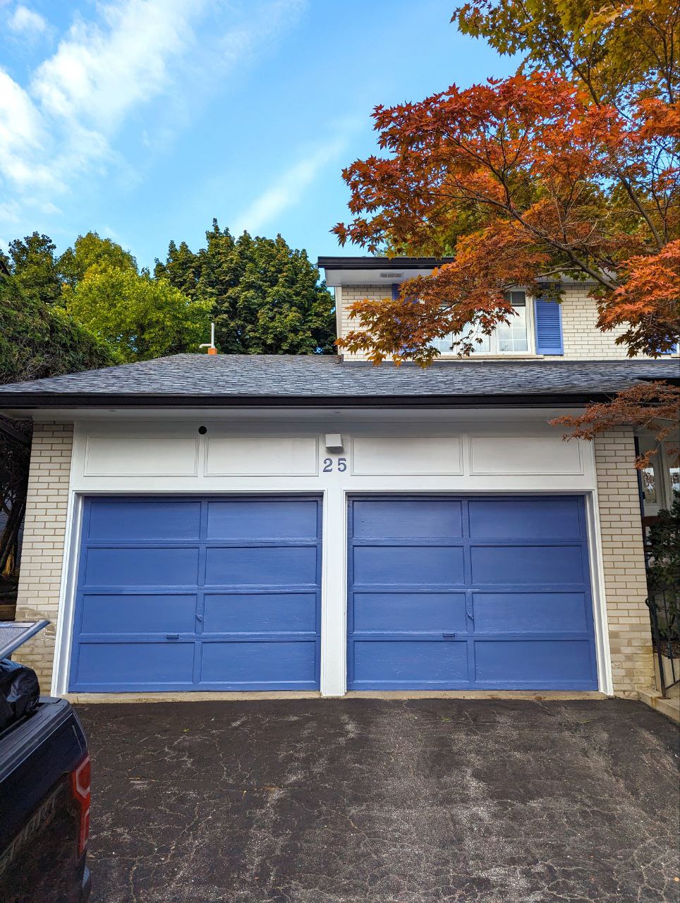 Exterior painting project in North York, Toronto: a double garage door and window shutters spray painted in a nice rich blue by BenjaminMoore and the fascia, suffit, and windows freshened up in the existing white colour.