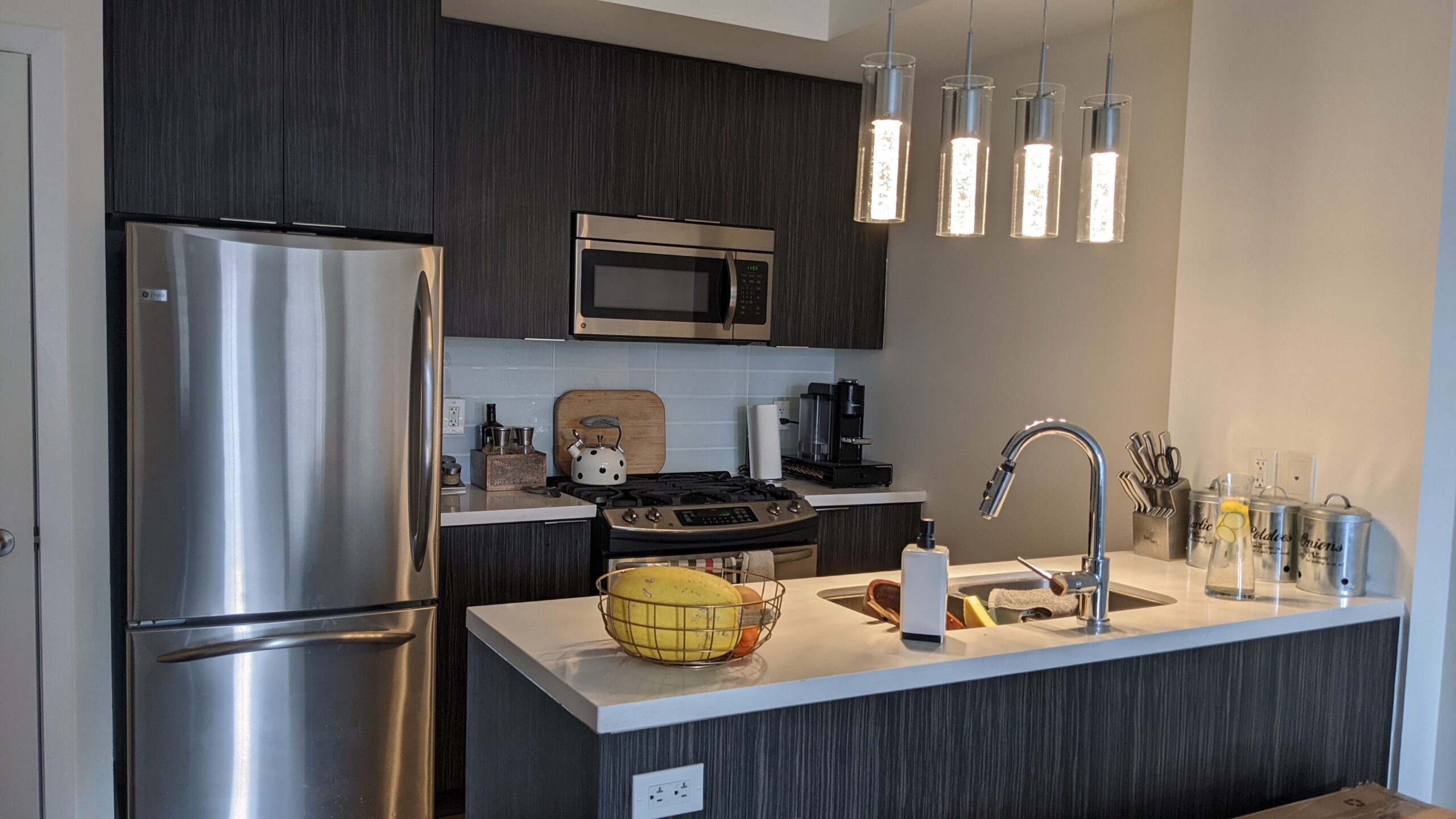 Outdated high-gloss slab doors in a small townhome kitchen, awaiting a stylish transformation in downtown Toronto