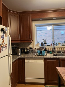 Stained MDF kitchen cabinets in a Toronto bungalow, awaiting a refreshing transformation in the Junction area