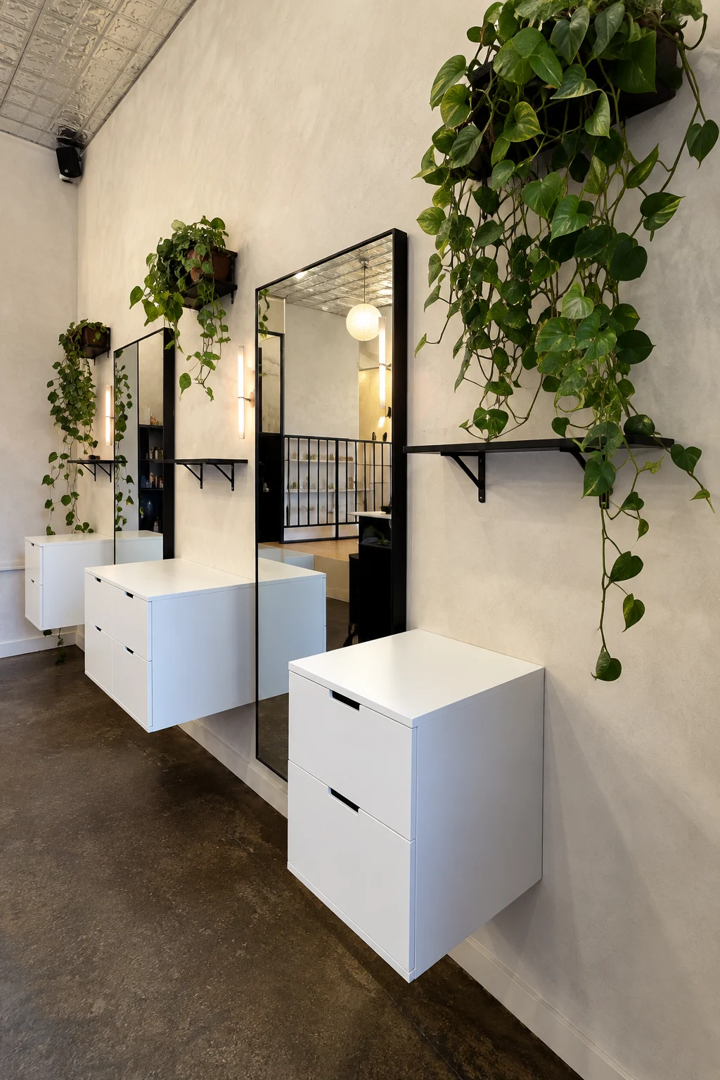 Toronto Hair Salon Limewash – Styling Station Detail Neutral limewash wall behind styling mirrors and plants in a Toronto hair salon