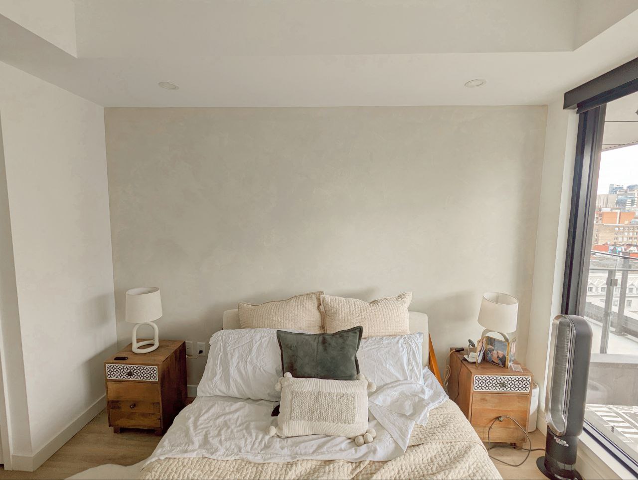 Modern Boho inspired bedroom with limewash accent wall in grayish beige color, showcasing textured finish.