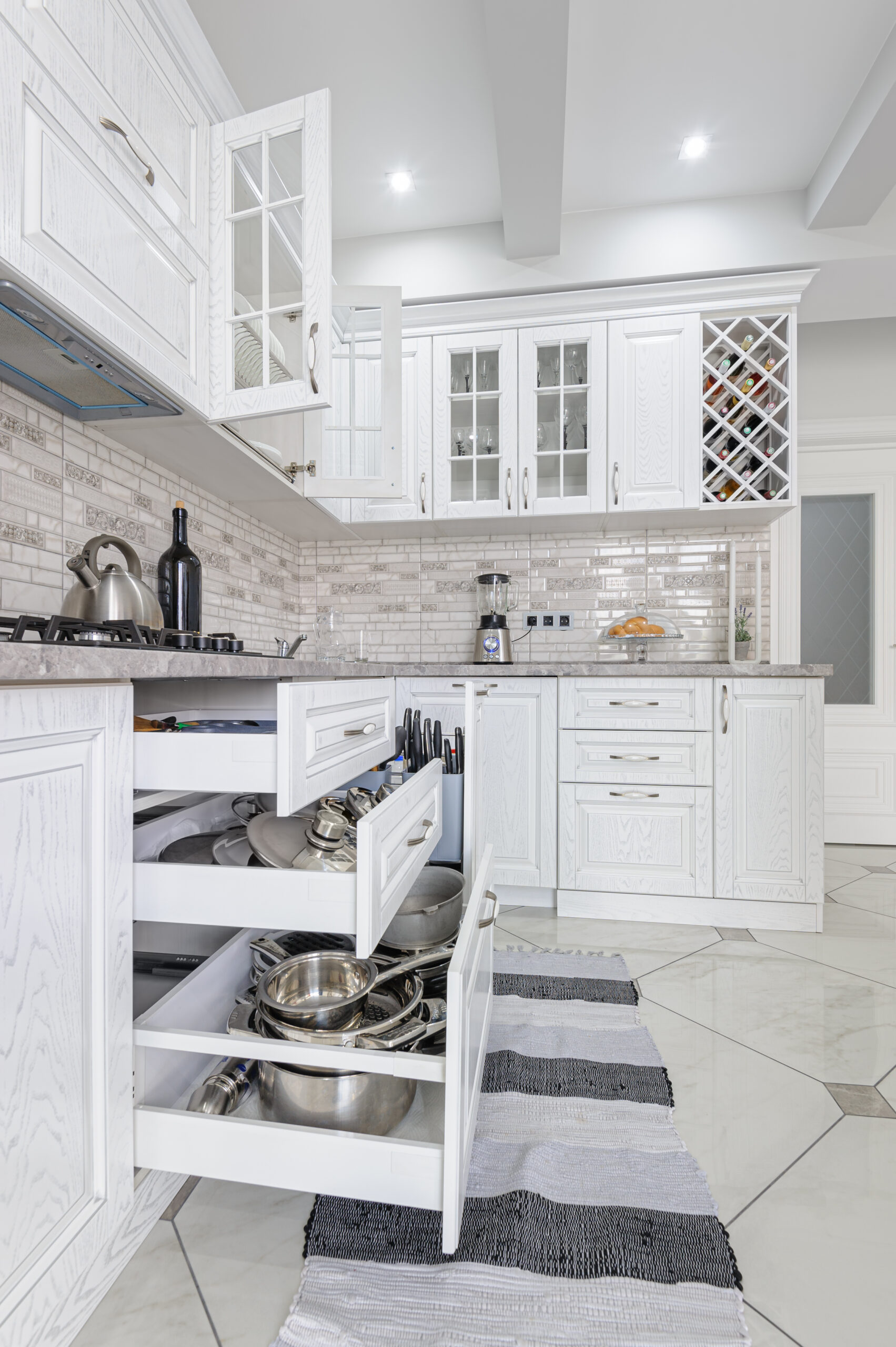 Chic and sophisticated kitchen cabinet painting in Newmarket - Chantilly Lace by Benjamin Moore adorns these beautifully spray-painted cabinets, creating a stylish focal point.