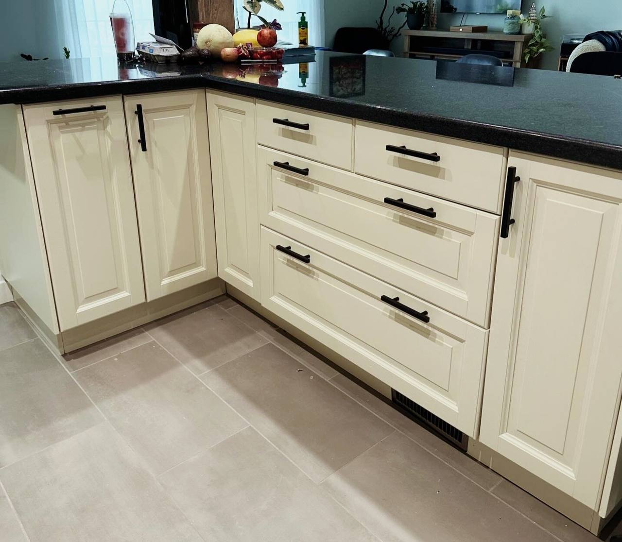 After image of kitchen island and cabinets, displaying the remarkable transformation to off-white with green undertones, following MDF cabinet painting in George Town, Toronto. Off-white painted kitchen cabinet color ideas: Misty Gray by Benjamin Moore