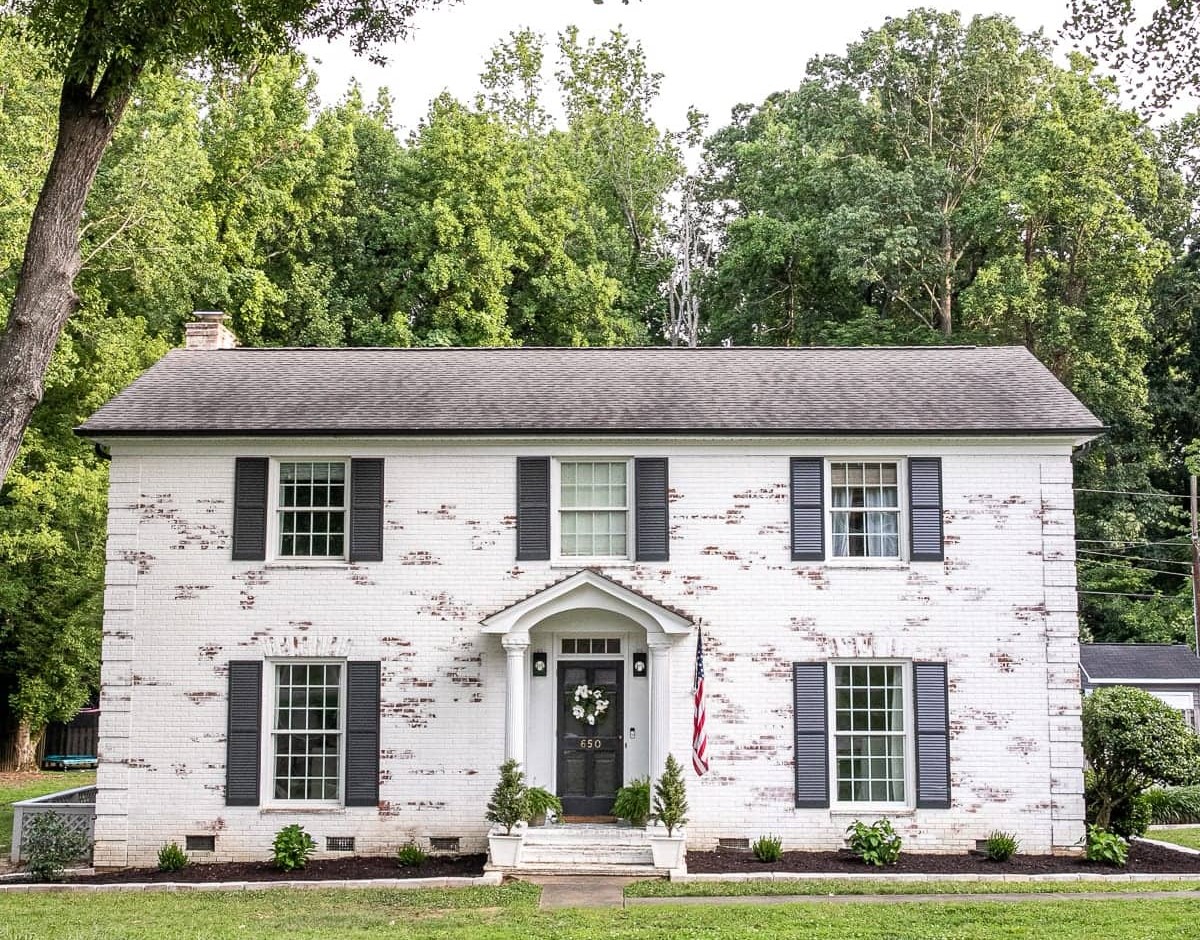 Exterior view of a farmhouse showcasing the charming texture and whitewashed appearance of limewashed brick walls