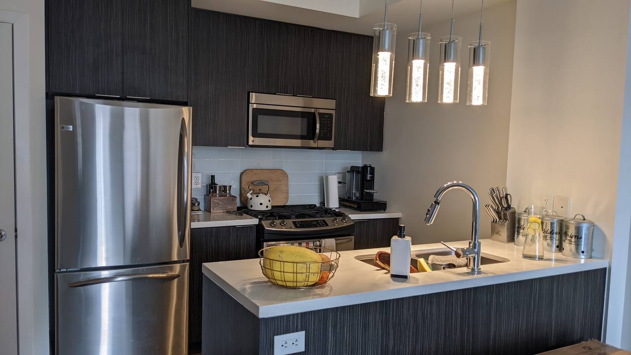 Before photo of a condo kitchen cabinet painting project in downtown Toronto: Warm Gray painted kitchen cabinet color ideas