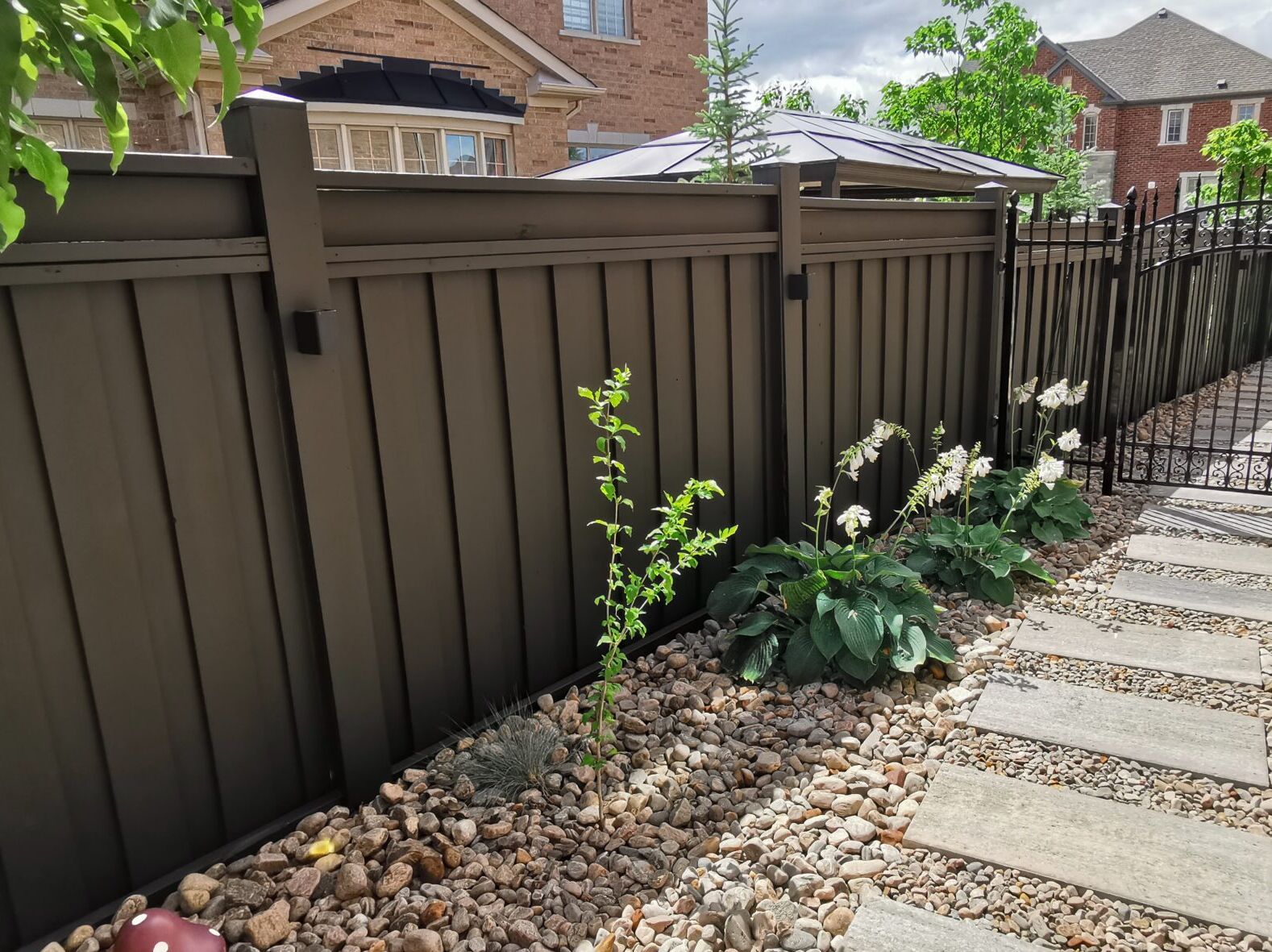 he same house in Patterson, Vaughan, post fence painting. The fence has been stained to a rich, natural hue, and the door is painted in Dark Grey by Sherwin Williams, giving the exterior a polished, modern look
