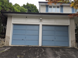 Before photo of a double garage doors in North York showing paint peeling, ready for professional garage door painting.