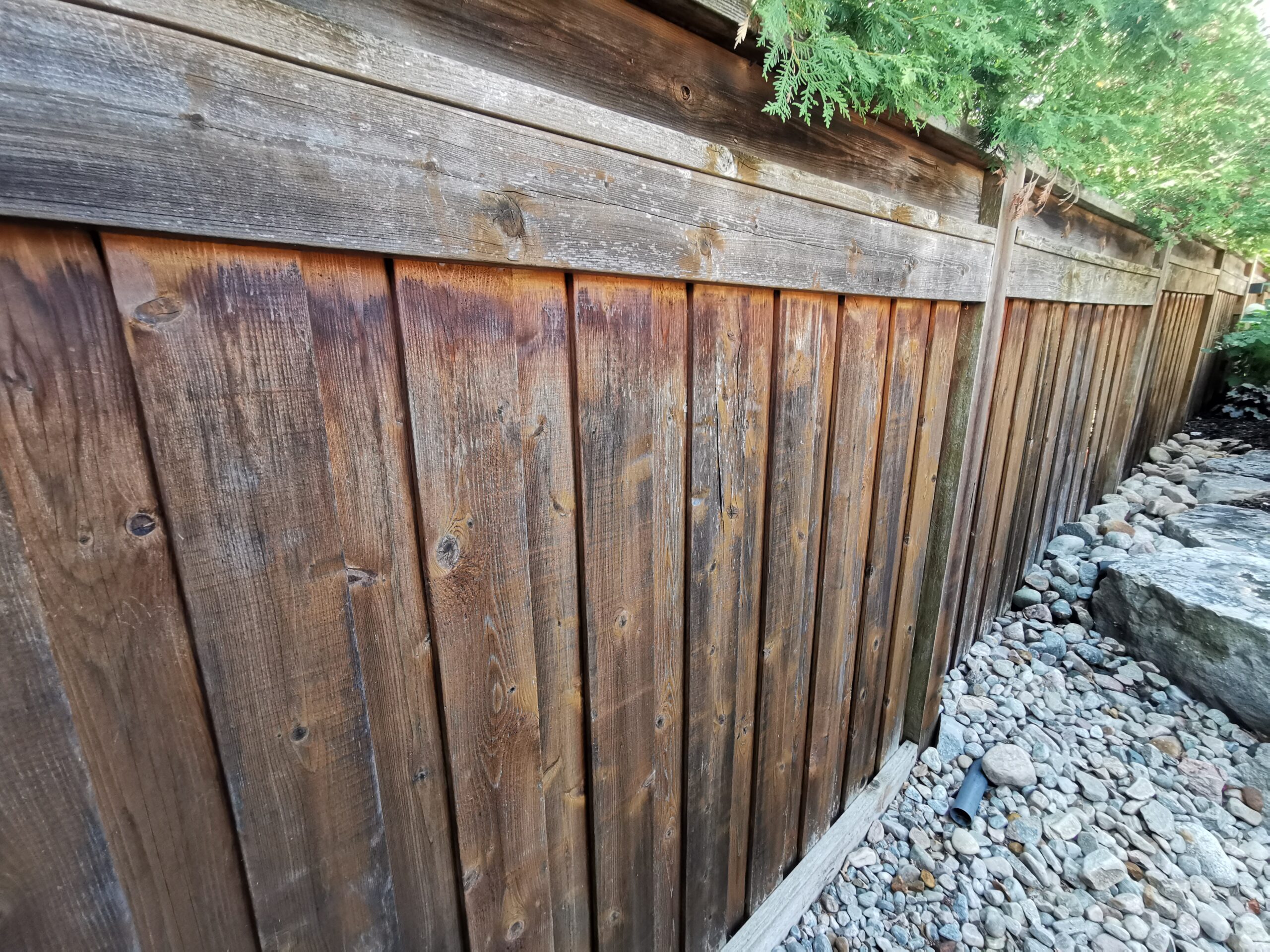 An exterior shot of a house in Patterson, Vaughan, featuring a dull, weather-beaten fence and an unfinished door.