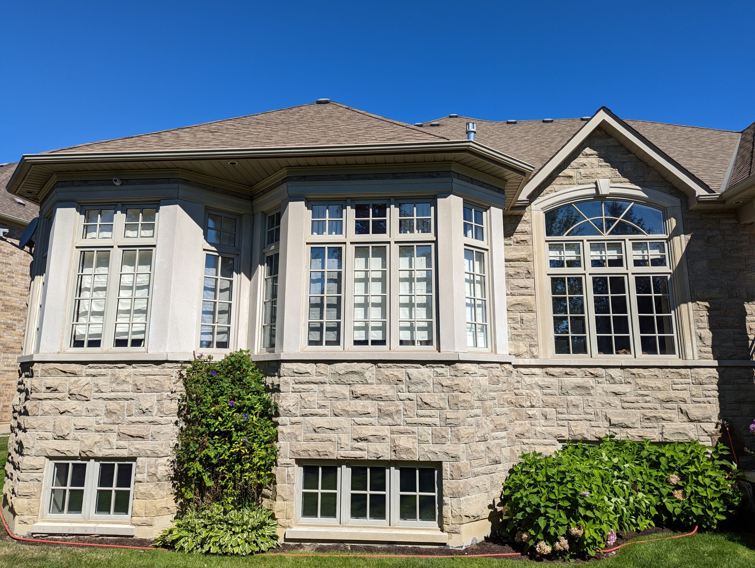 Vinyl windows in Kleinburg before painting, featuring a cream color finish. Preparation for painting included full Stix primer and patching.