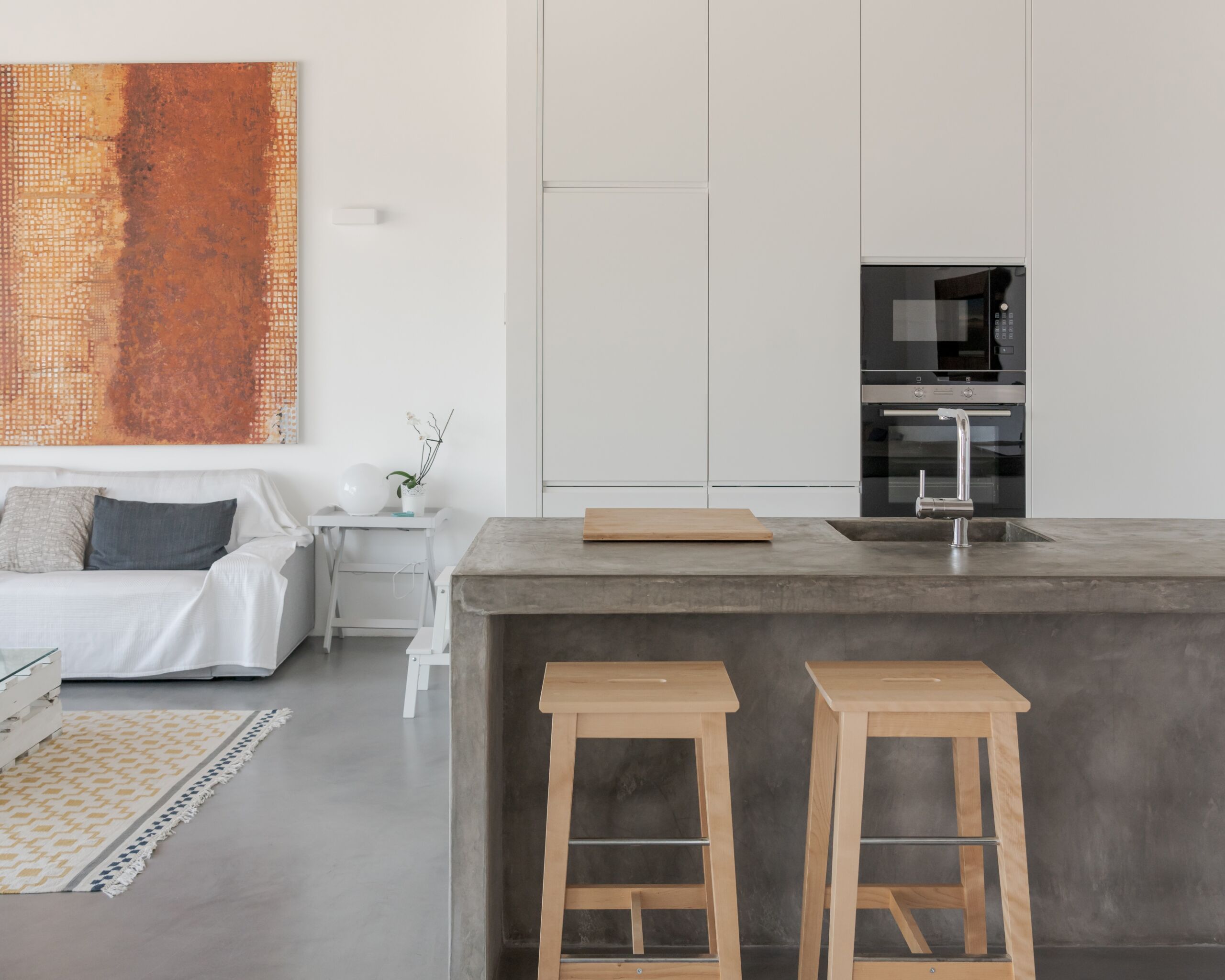 Kitchen island in dark warm gray microcement finish Kitchen island with a sleek microcement finish in Leaside, showcasing a modern and seamless design