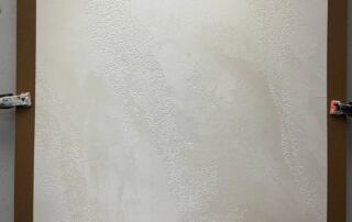 Venetian plaster sample in pearl finish presented to Etobicoke client for modern fireplace surfacing option.