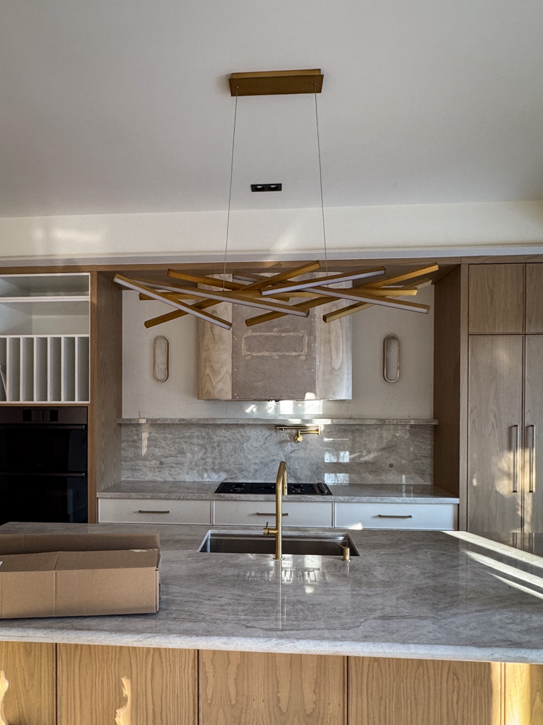 Newly built wood range hood and painted kitchen wall before microcement application.