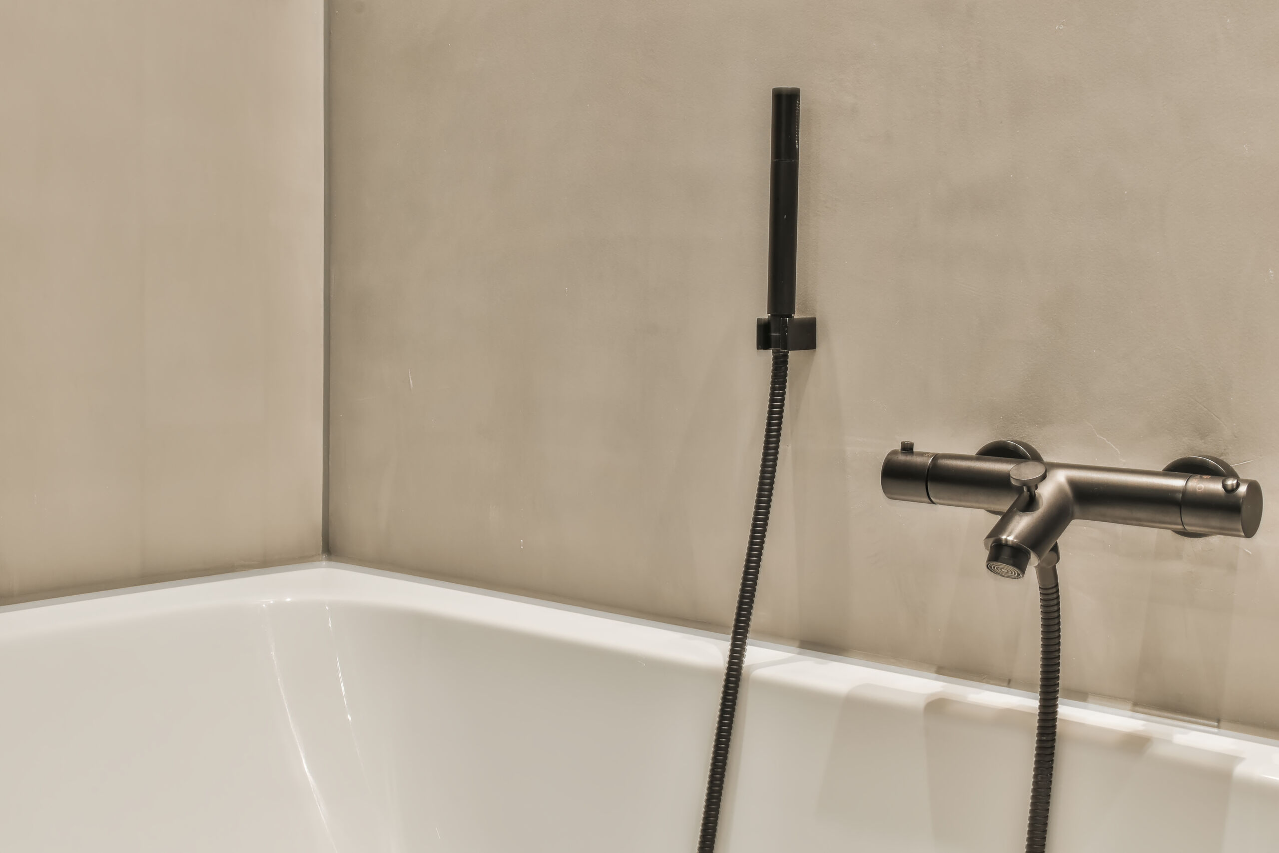 Elegant bathroom interior microcement bathroom, walls reaching a bath tub, modern design.