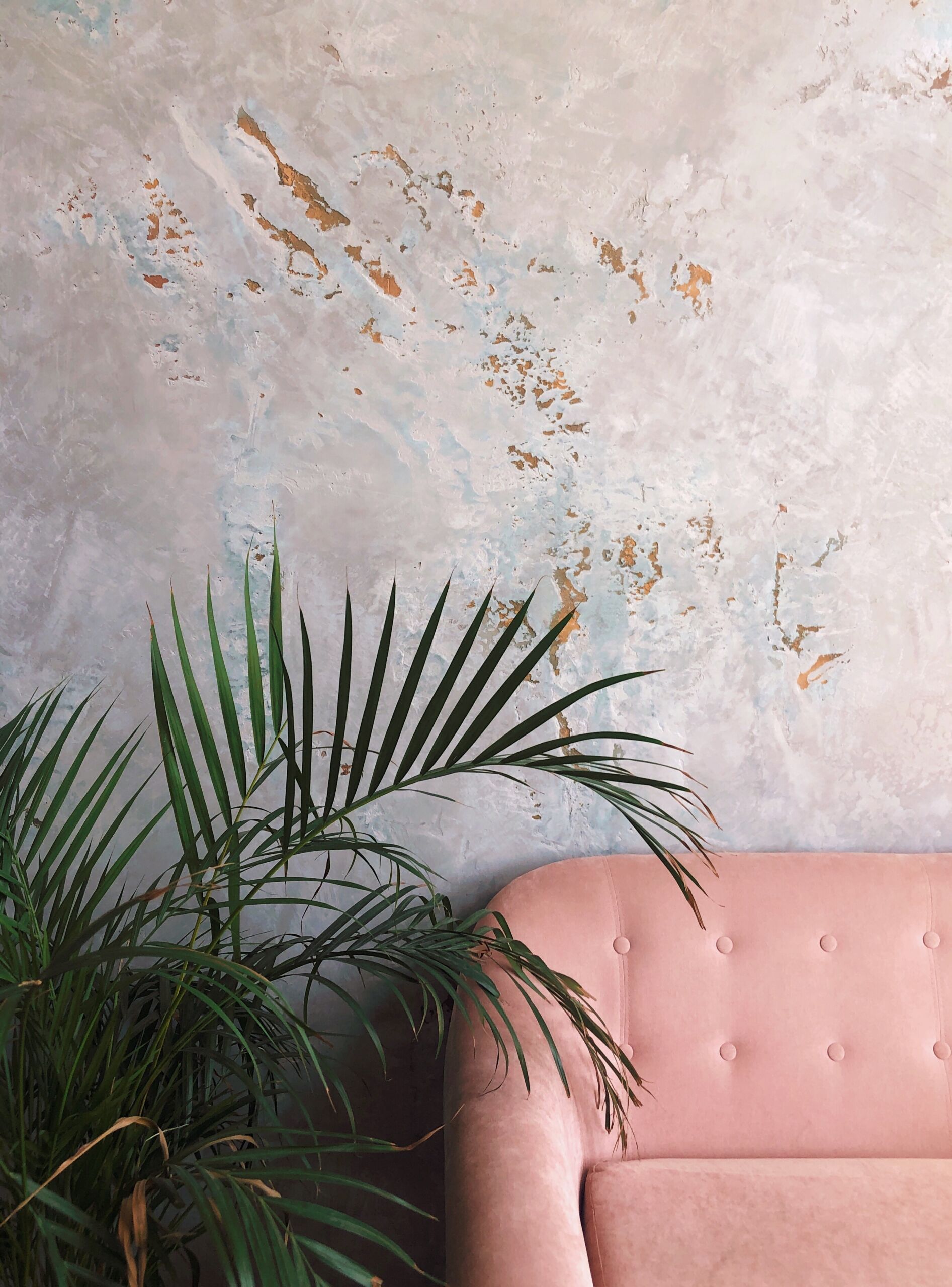 hire-venetian-plaster-contractor-near-me-in-toronto-for-luxury-wall-finishespiece-of-a-pink-sofa-and-a-green-splay-near-a-conc-2025-01-09-02-21-47-utc rustic looking wall finished in venetian plaster by luxury wall specialists in toronto