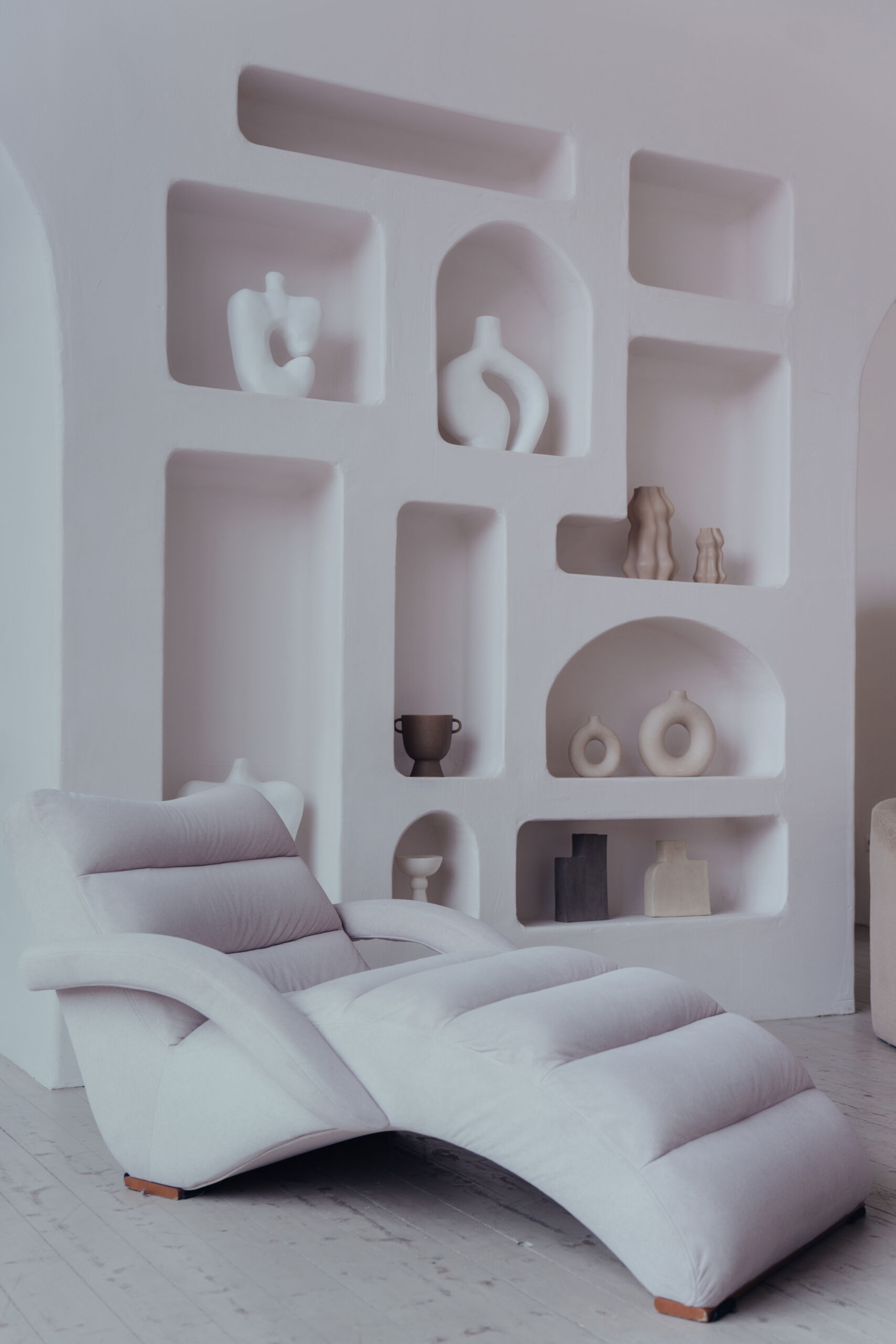 Soft bone-coloured Tadelakt brings sculptural elegance to this curved feature wall with custom niches in a Toronto residence. Tadelakt plaster feature wall with curved niches in soft bone colour in Toronto home interior