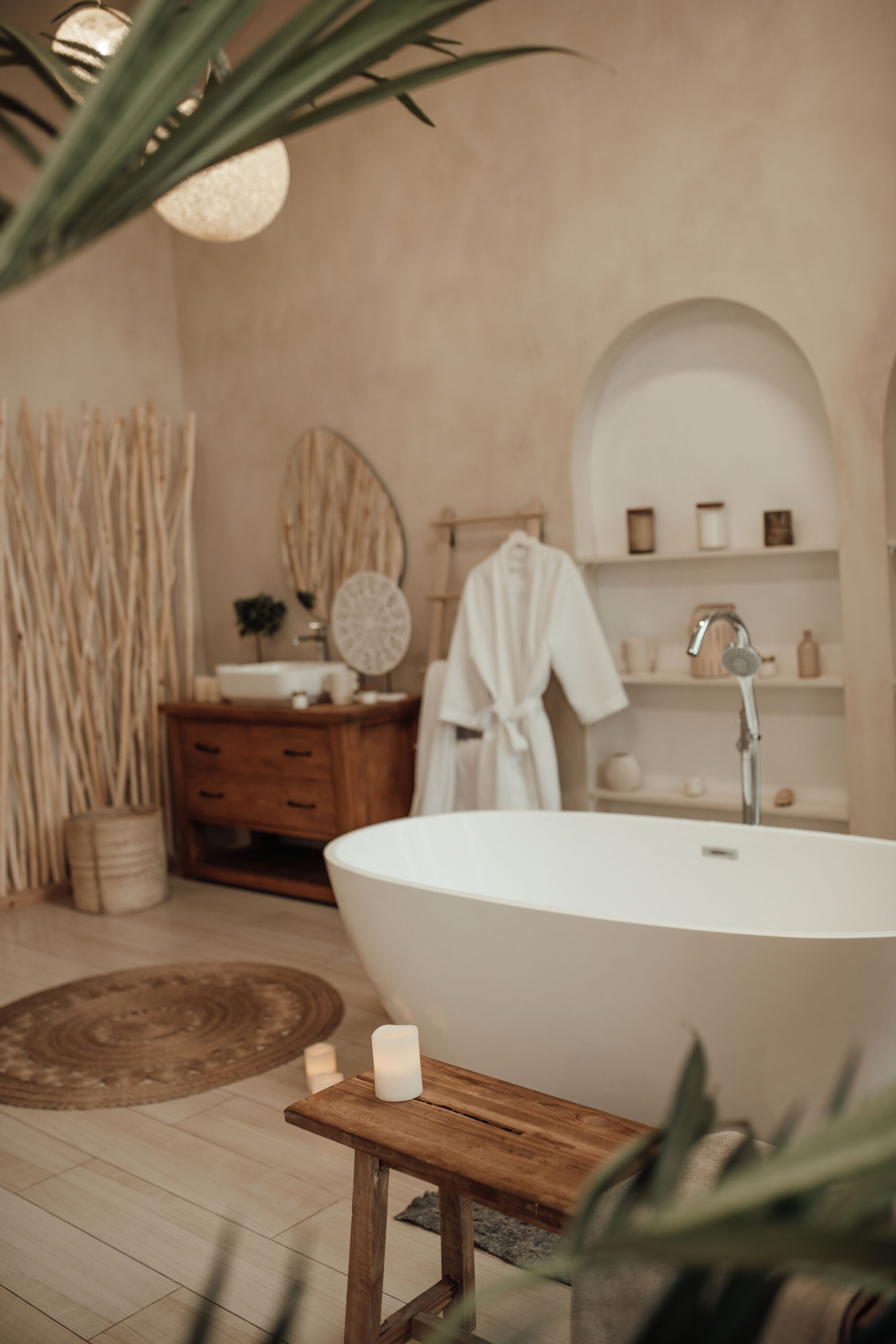 Luxury interior of big bathroom at modern african style with oval bathtub in natural lighting Soft off-white neutral tadelak finish in organic shapes of a luxurious bath tub.