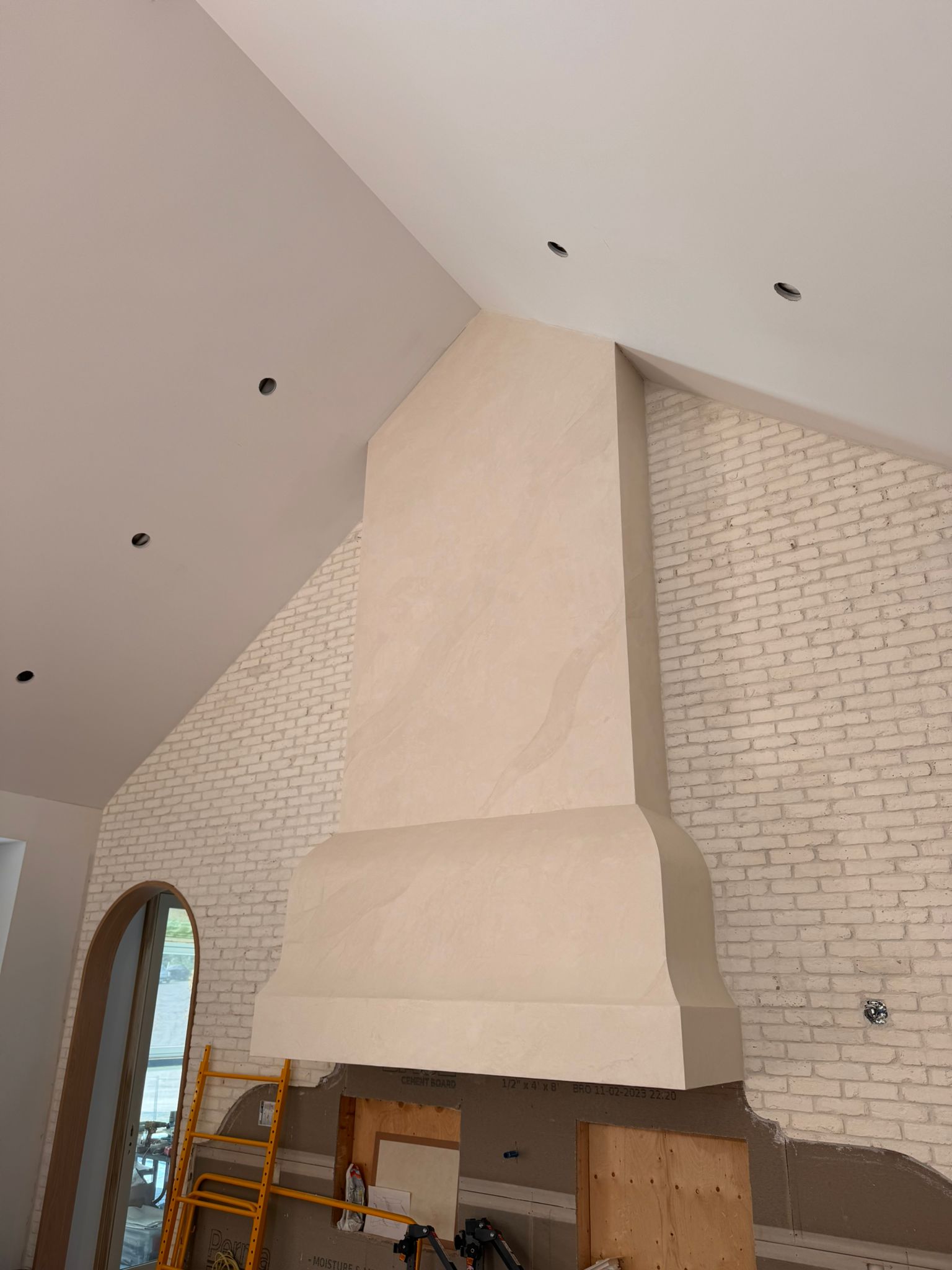 warm-white-venetian-plaster-pearl-range-hood-kleinburg Tall range hood in a Kleinburg kitchen finished in a warm white Venetian Plaster Pearl for a seamless, iridescent texture.