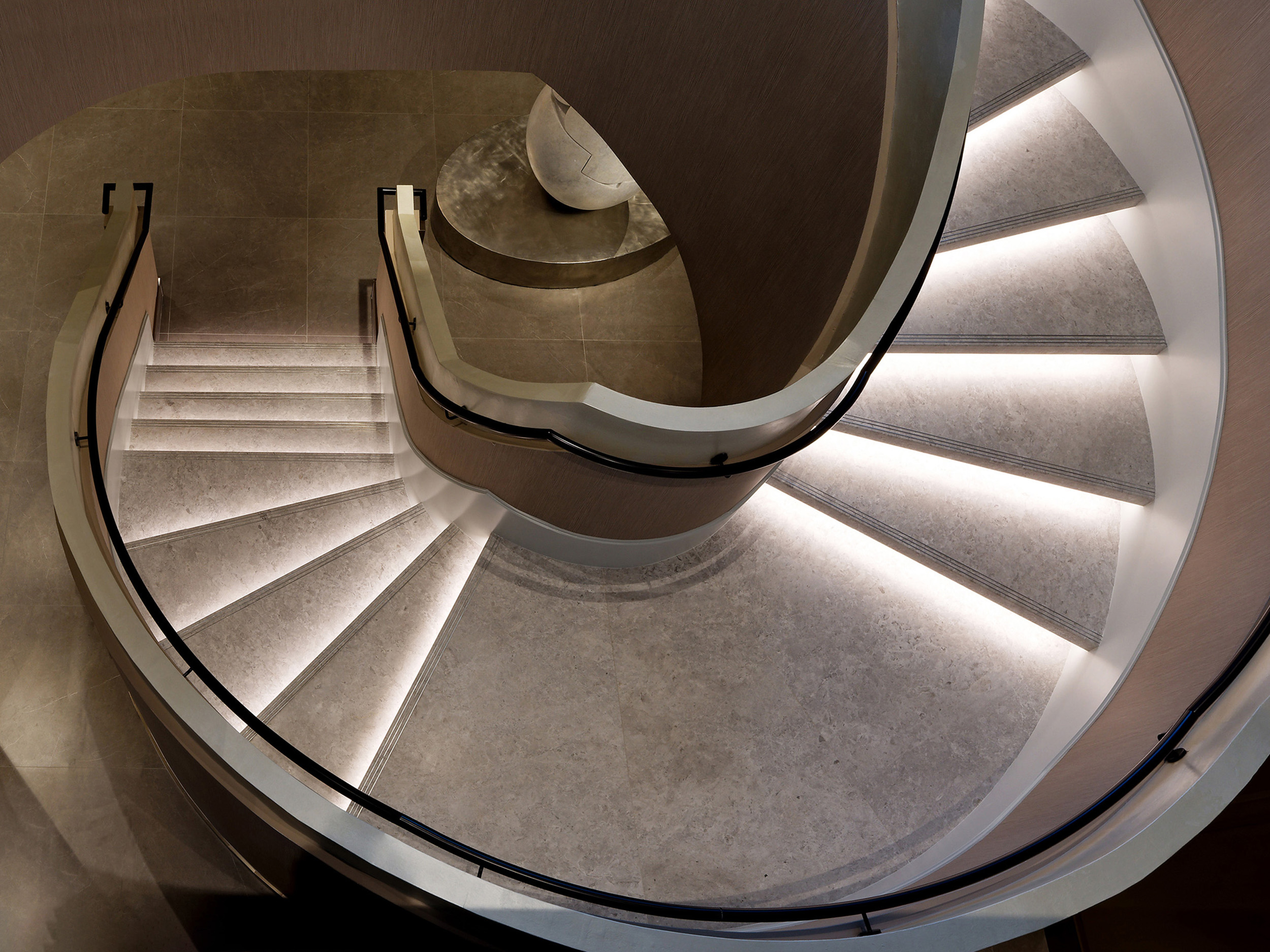 Royal-Bayview-Venetian-Plaster-Pearlescent-Handrail-Thornhill Close-up of a commercial lobby staircase handrail coated in smooth, shimmering pearlescent Venetian plaster.