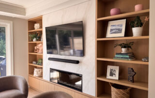 A modern living room fireplace and TV wall in Etobicoke, finished with a luminous pearly venetian plaster in a soft, light color.