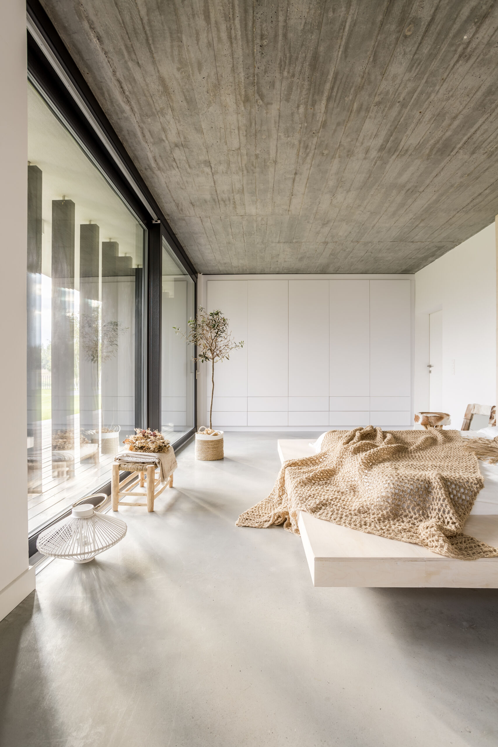 Polished Concrete vs Microcement — Modern Bedroom Floor with Microcement Finish Polished concrete vs microcement modern bedroom floor finished in seamless microcement.