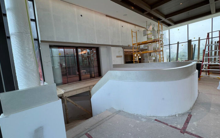 Lobby staircase at Royal Bayview in Thornhill featuring a custom Venetian plaster finish in off-white and champagne tones.