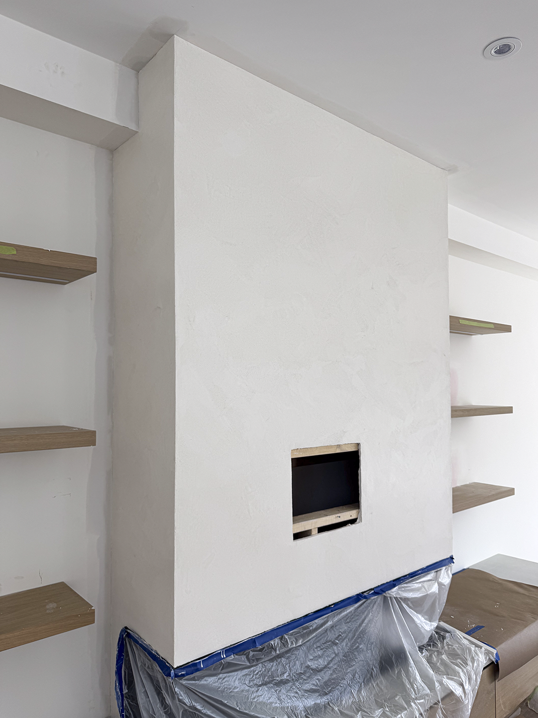 After photo showing white Venetian plaster surfacing over fireplace in Etobicoke, completed by Chromatist.