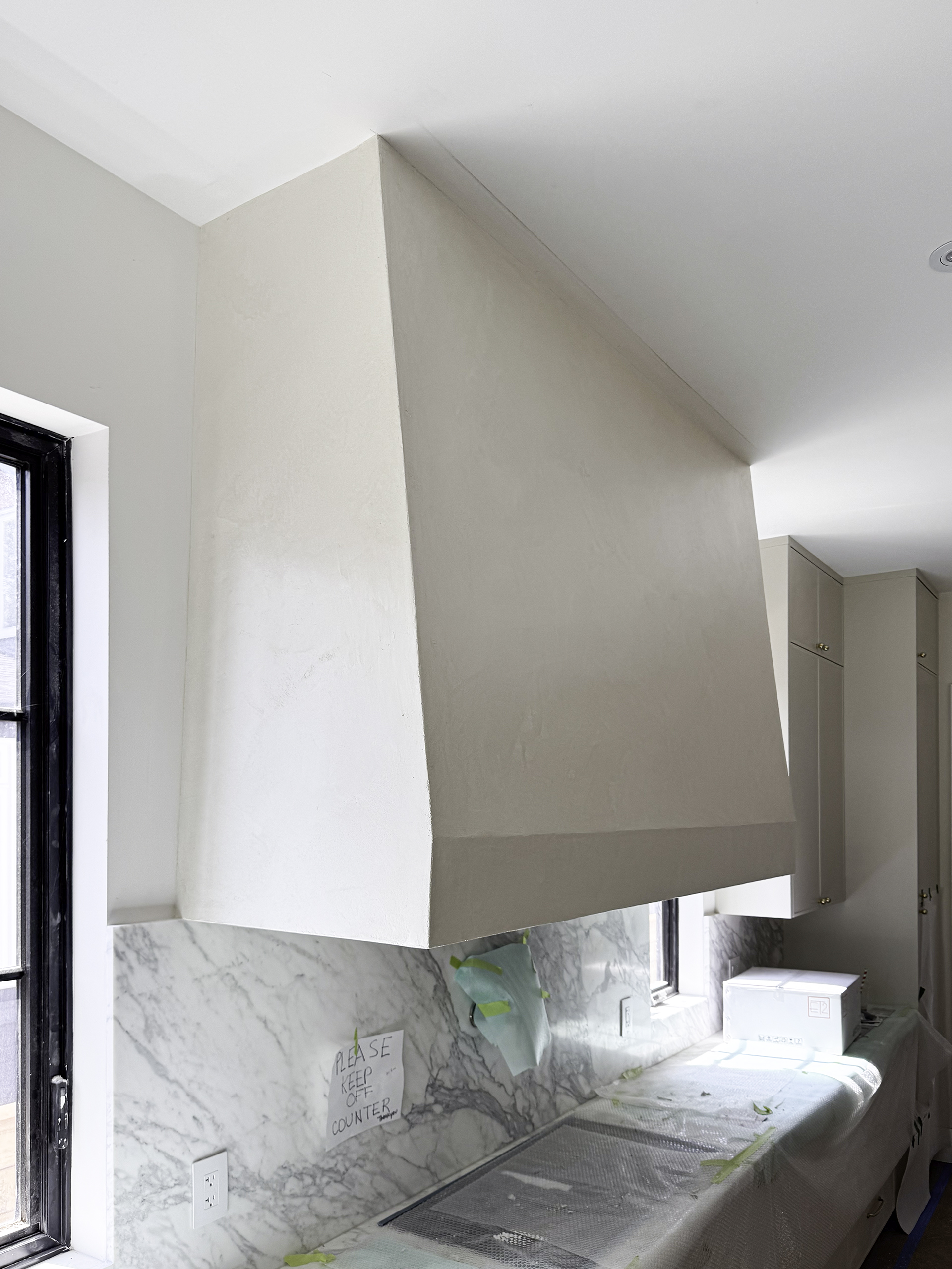 A close-up shot of the textured surface of a kitchen hood finished with Marmorino Venetian plaster, showing the natural, subtle sheen.