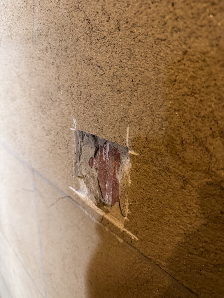before-historic-plaster-repair-and-restoration-university-of-toronto-1 Before photo of a severely damaged historic plaster wall at the University of Toronto's Simcoe Hall, showing a bit cut in the wall.