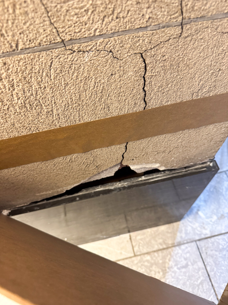historic-plaster-repair-samples-making-for-university-of-toronto-2 Before photo of a severely damaged historic plaster column at the University of Toronto's Simcoe Hall, showing deep cracks, scuffs, and visible signs of deterioration.