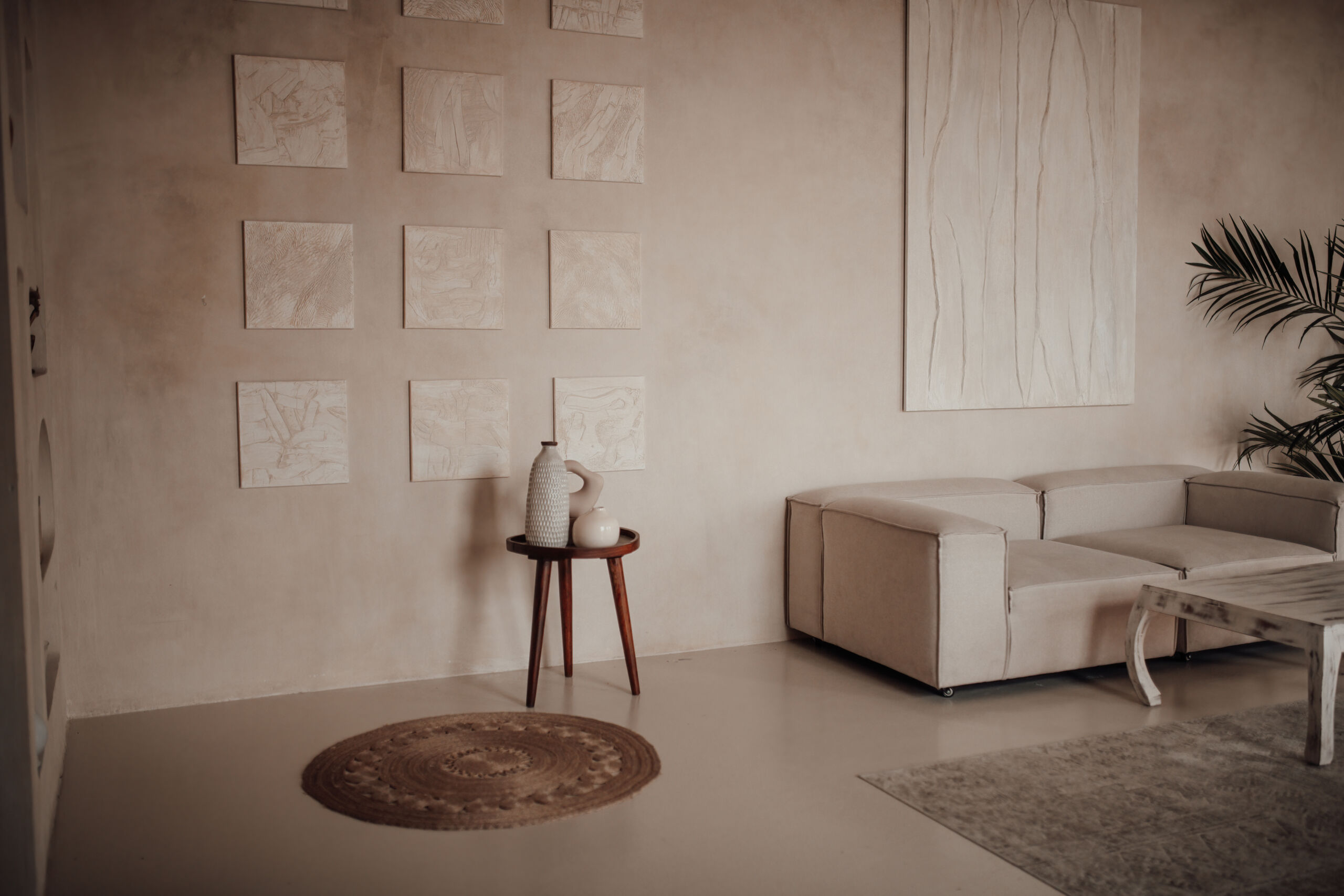 Luxurious hotel interior with elements of traditional Balinese design minimalist earth tones style Modern rustic living room with sandy off-white plaster walls and microcement flooring