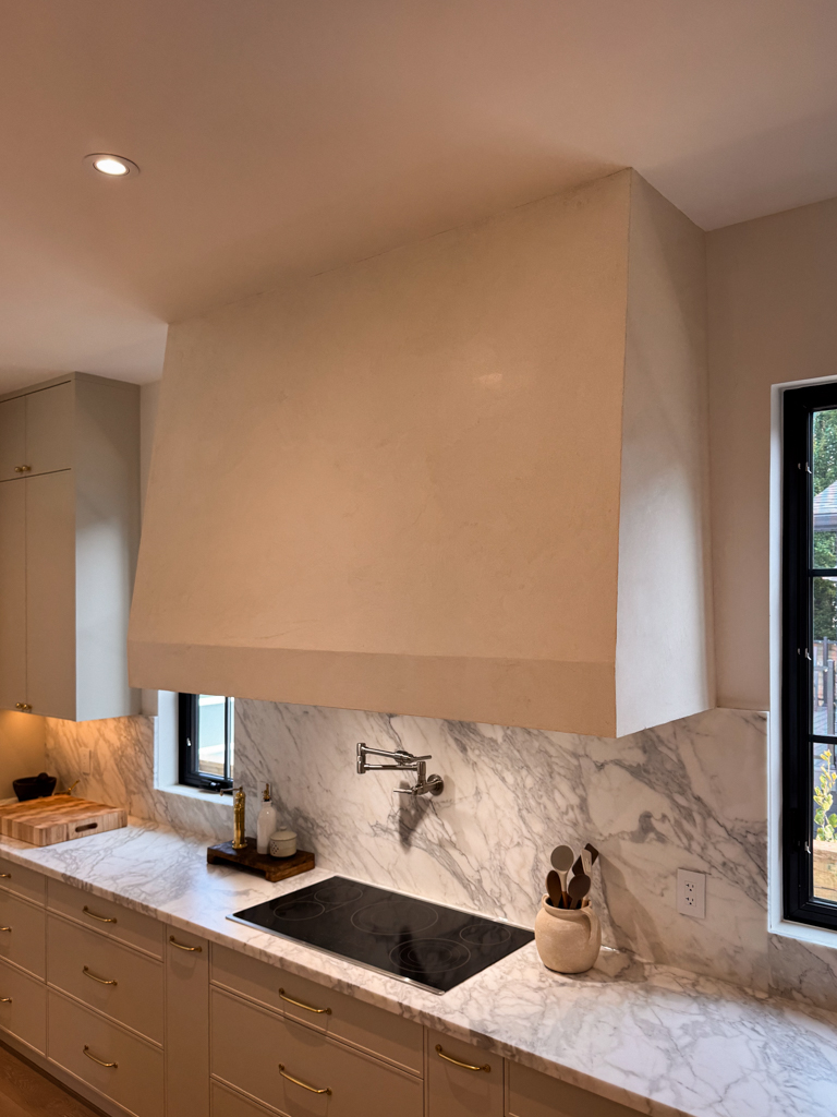 warm-white-marmorino-venetian-plaster-range-hood-mississauga-toronto-1 A finished kitchen hood with a smooth, off-white Marmorino Venetian plaster surface and a subtle sheen.