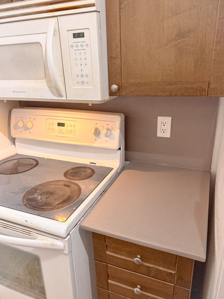 Microcement-kitchen-renovation-microcement-backsplash-microcement-countertop-yorkville,-bloor-1 A newly renovated kitchen featuring a seamless, light gray microcement finish on the countertops and backsplash, giving the space a modern and minimalist look.