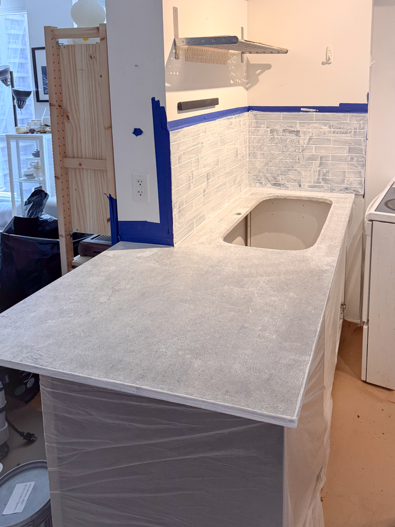 A kitchen counter and backsplash primed with a bonding agent, showing a clean and prepared surface ready for the first coat of microcement.
