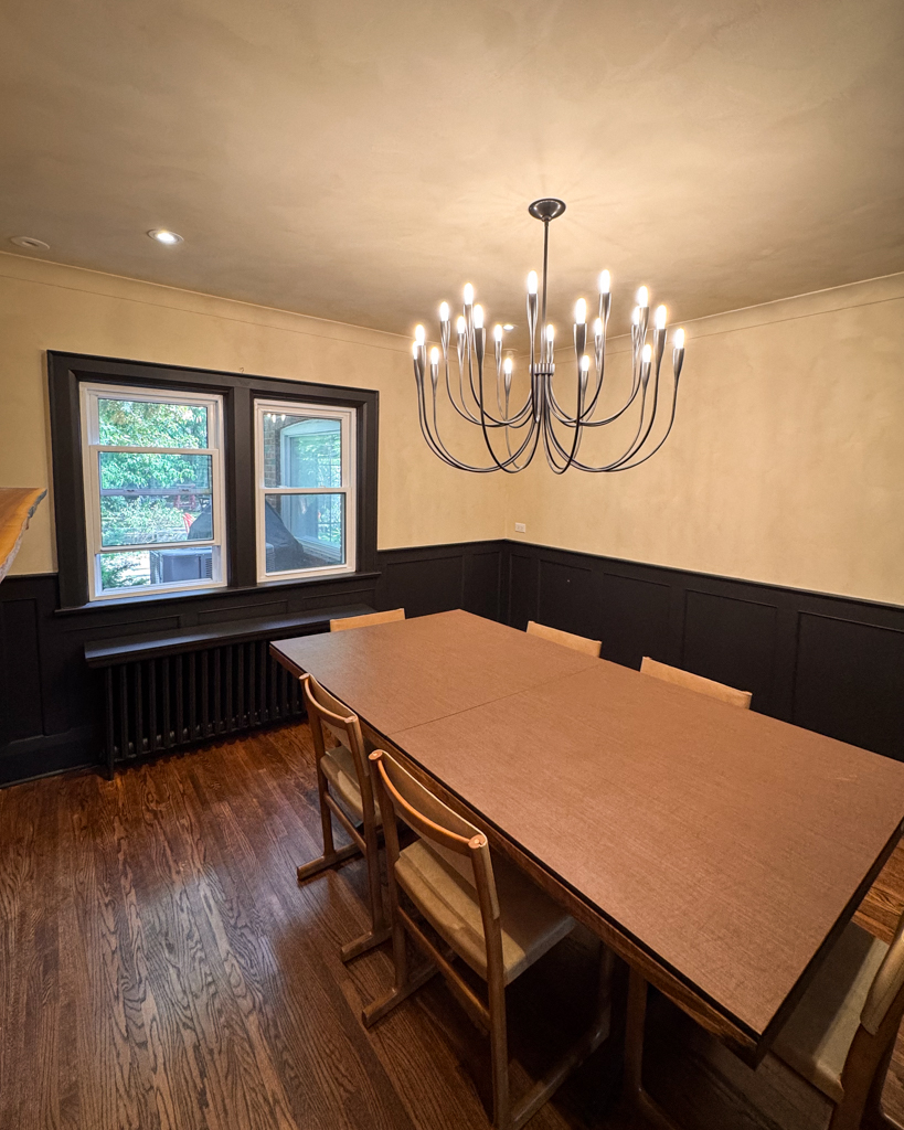 interior-limewash-dining-room-creamy-beige-bloor-west-village-toronto-4 xA beautifully finished living room interior in a Tudor home, featuring creamy limewash walls and black wainscotting, creating a rich, old-world aesthetic.