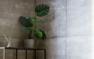 Seamless concrete effect wall finish in a modern Toronto home foyer, featuring hand-troweled cement plaster texture and minimalist architectural lighting.