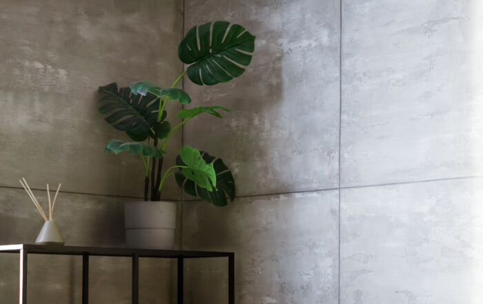 Seamless concrete effect wall finish in a modern Toronto home foyer, featuring hand-troweled cement plaster texture and minimalist architectural lighting.