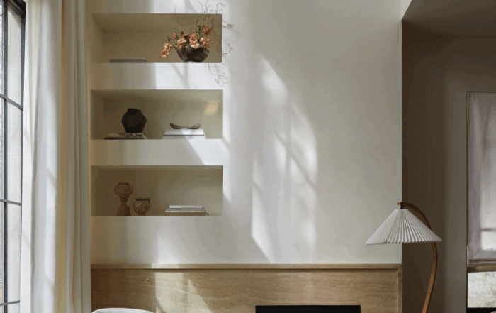 A towering 21-foot fireplace finished in a warm lime plaster, showcasing subtle texture in a Summer Hill residence living room.