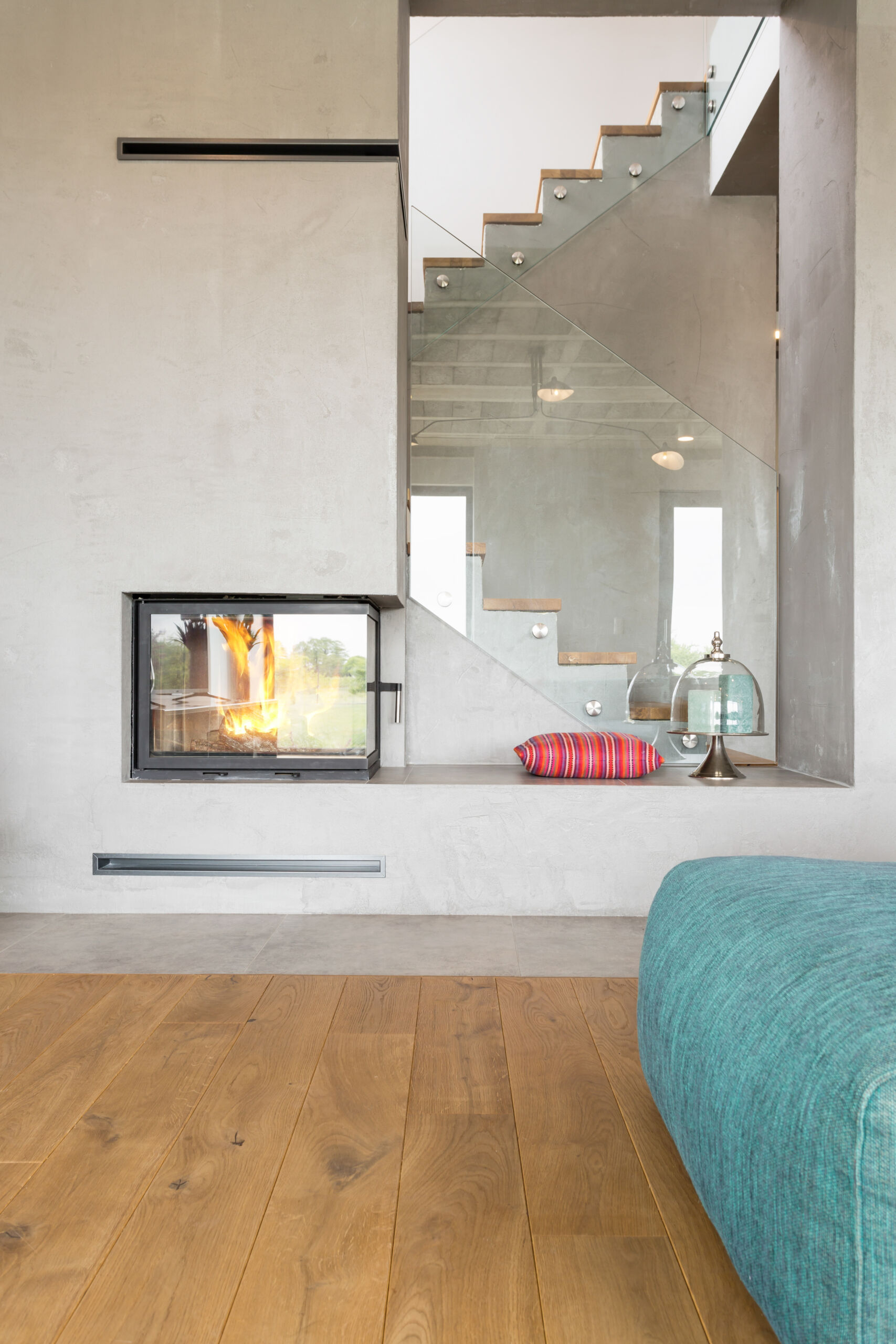 microcement-fireplace-industrial-look-design Contemporary microcement fireplace surround featuring a raw industrial look and a seamless, monolithic design.
