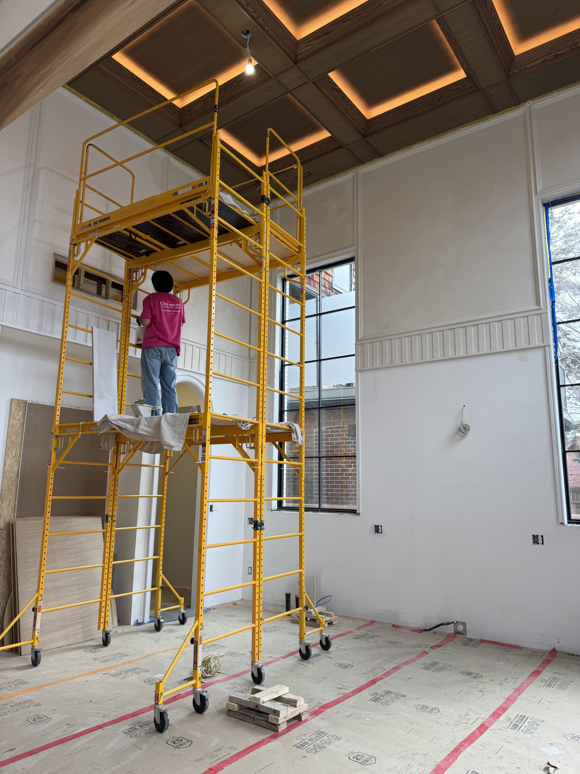Custom Stained Red Oak Ceiling Panels Luxury coffered ceiling featuring custom-stained red oak ceiling panels and crisp white framing, protected by a professional varnish and accented with integrated hidden lighting.