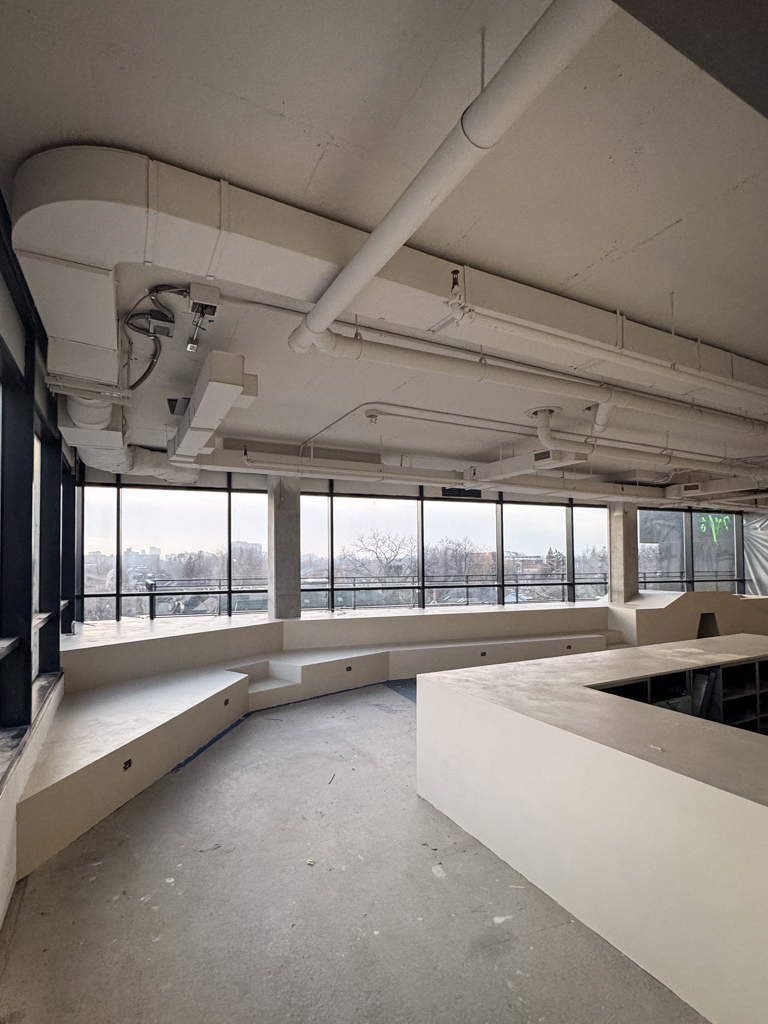 Seamless microcement installation on a modern cafe countertop and surrounding kids' playground area in a Toronto commercial space.