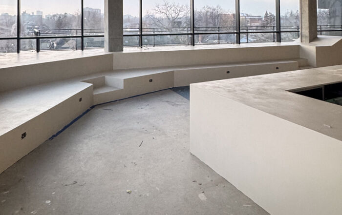 Seamless microcement installation on a modern cafe countertop and surrounding kids' playground area in a Toronto commercial space.