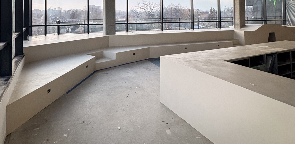 Seamless microcement installation on a modern cafe countertop and surrounding kids' playground area in a Toronto commercial space.