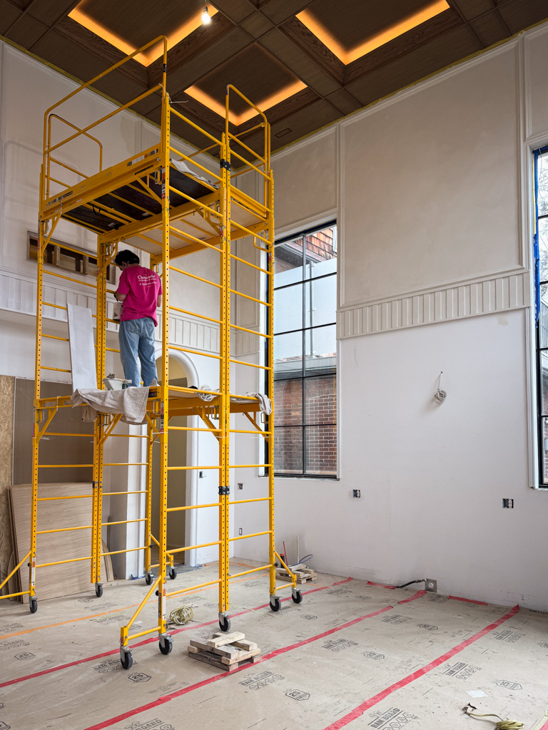 Chromatist limewash painters on a three-storey scaffold applying a traditional Limewash finish to high-vaulted walls and integrated wall frames in a luxury home in The Beaches, Toronto.