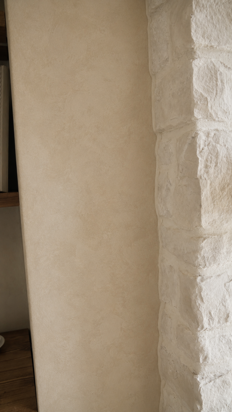 microcement-media-unit-curved-niches-adjacent-to-masonary-fireplace-in-grand-room-kleinurg5 Close-up of seamless microcement transition between curved media unit and stone fireplace