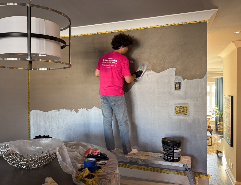 bamboo-design-microcement-walls-living-room-in-etobicoke-6 An artisan using trowel to apply microcement over primed walls.